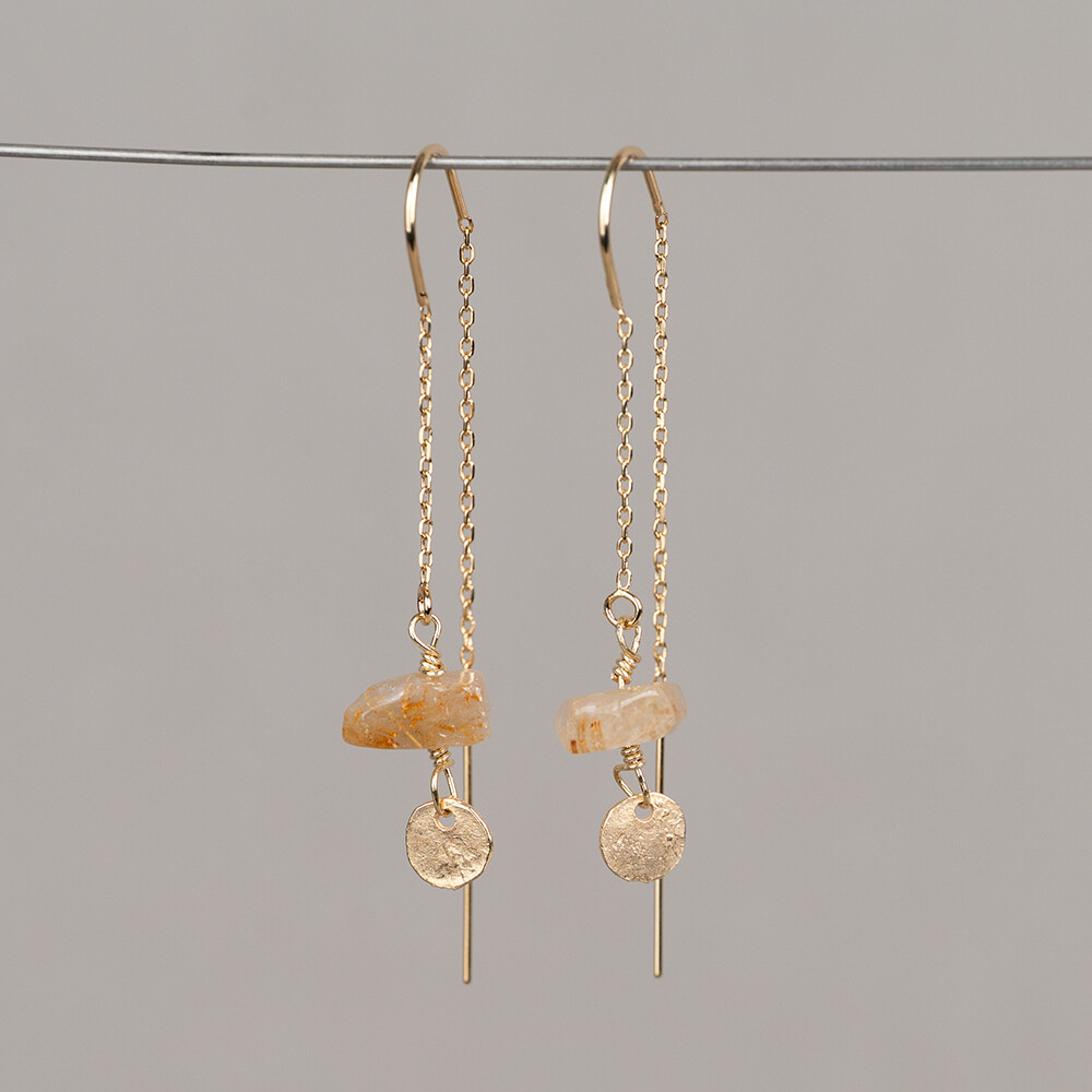 Deze doortrek oorhangers zijn uitgevoerd in verguld zilver en voorzien van een Touch of Gold afwerking. De U-vormige beugel zorgt voor een comfortabele pasvorm en houdt de oorbel goed op zijn plek. Onderaan hangt een organische cirkel waar een Gold Rutiel met de hand aan is bevestigd. Gold Rutiel is een kwartsvari&euml;teit met goudkleurige naaldinsluitingen die elk exemplaar een unieke tekening geven. De steen heeft een warme, gouden tint die goed aansluit bij de Touch of Gold afwerking van de oorbel. Edelstenen zijn natuurproducten; kleur en formaat kunnen afwijken van de afbeelding. De oorhangers maken deel uit van de Mix & Match collectie van Jeh Jewels, een Nederlands sieradenmerk opgericht in 1991.