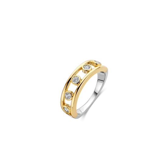 Deze opvallende TI SENTO ring combineert warme glans met een speels opengewerkt ontwerp. De ring is gemaakt van hoogwaardige kwaliteit 925 sterling zilver en is uitgevoerd in een goudkleurig vergulde afwerking. In het midden van de band zijn ronde zirkonia steentjes verwerkt, met open ruimtes ertussen die de ring een luchtige en moderne uitstraling geven. Deze goudkleurig vergulde ring met zirkonia is een stijlvol statement om solo te dragen en laat zich ook mooi combineren met andere ringen in een verfijnde ring stack. Het open ontwerp en de fonkelende stenen geven zowel een dagelijkse look als een meer geklede outfit een elegante touch.