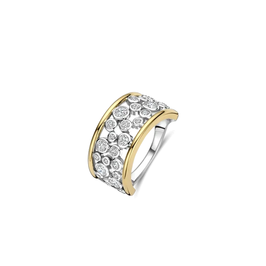Deze opvallende TI SENTO ring combineert warme glans met een luchtig en sprankelend ontwerp. De ring is gemaakt van hoogwaardige kwaliteit 925 sterling zilver en bestaat uit twee gladde goudkleurig vergulde banden. Daartussen schitteren meerdere rond geslepen zirkonia stenen, geplaatst met open ruimtes ertussen. Dit open ontwerp geeft de brede ring een lichte, moderne uitstraling. Deze goudkleurig vergulde ring met zirkonia is een sterk statement om solo te dragen. Combineer hem met subtiele goudkleurige sieraden om de warme glans te benadrukken, of draag hem naast andere ringen voor een uitgesproken ring stack.