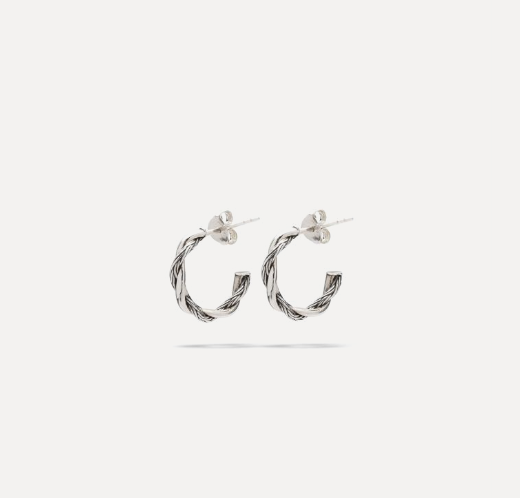 De Hoops Katja Twist Zilver Set brengt het herkenbare karakter van de Katja-collectie samen met een verfijnde en moderne uitstraling. De subtiele twistdetails geven deze hoops extra diepte en beweging, terwijl de gewoven structuur zorgt voor een elegante balans tussen kracht en verfijning. Vervaardigd uit premium gerecycled 925 zilver en ontworpen in Amsterdam. Met de hand gemaakt in Zuid-Oost Azi&euml; door ervaren ambachtslieden die ieder detail zorgvuldig afwerken. Dankzij het tijdloze ontwerp zijn deze hoops moeiteloos te combineren met andere sieraden en geschikt voor zowel dagelijkse momenten als bijzondere gelegenheden.