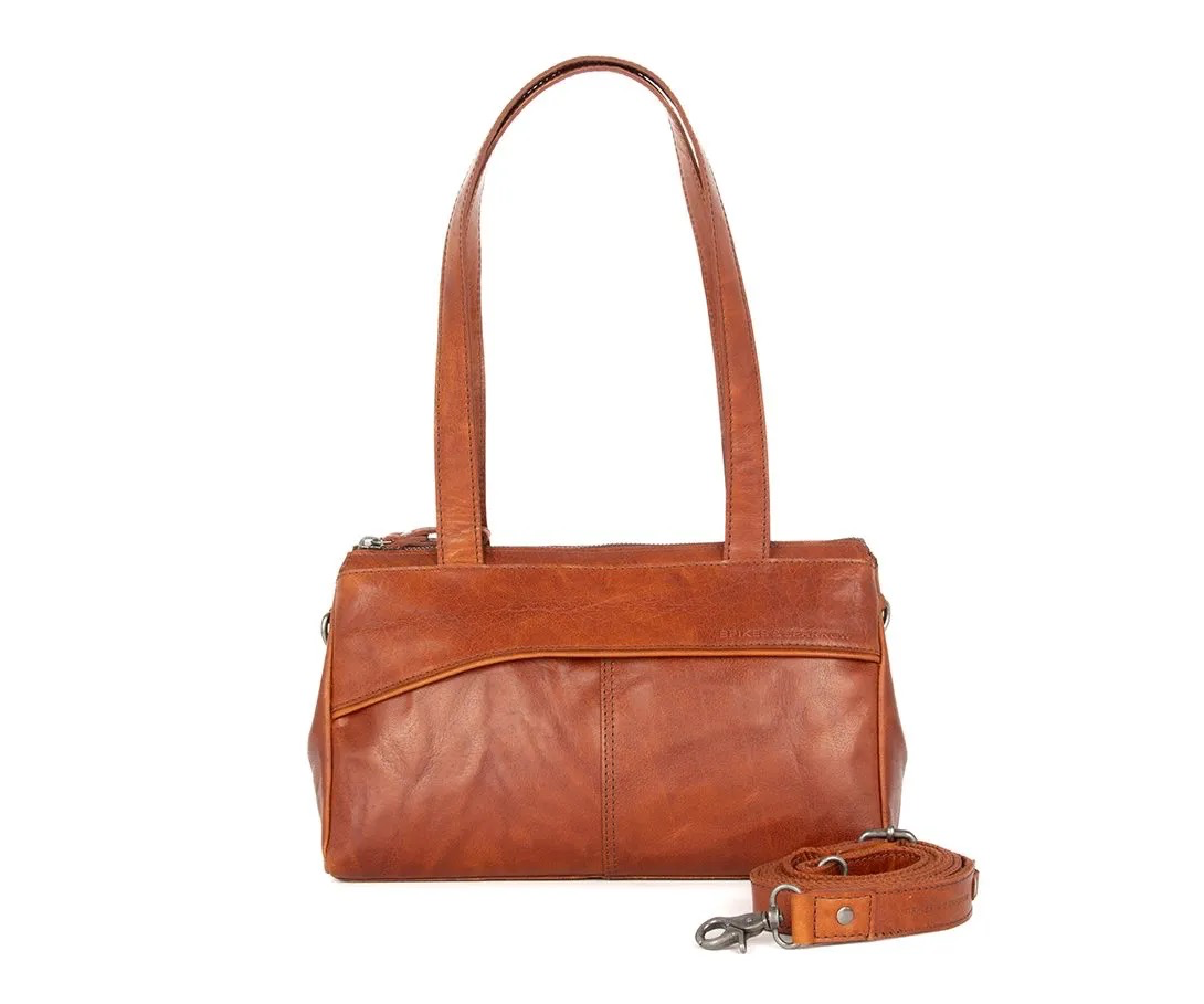 Handtas Alicia cognac &ndash; stijlvolle leren dameshandtas
Tijdloos, vrouwelijk &eacute;n verrassend praktisch: handtas Alicia in cognac is een elegante leren handtas voor dames die stijl en functionaliteit moeiteloos combineert. Het verfijnde lijnenspel aan de voorzijde geeft de tas een moderne en vrouwelijke uitstraling. De warme cognackleur zorgt bovendien voor een stijlvolle en veelzijdige look die gemakkelijk te combineren is met verschillende outfits.
Aan de voorzijde bevindt zich een slim verborgen voorvak met magneetsluiting. Ideaal voor spullen die je snel bij de hand wilt hebben, zoals je telefoon, sleutels of zonnebril. Het hoofdvak sluit met een rits en aan de achterkant bevindt zich nog een praktisch achtervak met rits.

Praktische indeling
Handtas Alicia is niet alleen mooi, maar ook bijzonder praktisch ingedeeld. Binnenin vind je een tussenschot met rits, een extra ritsvak, twee insteekvakken, twee pennenlusjes en een handig sleutellusje. Hierdoor kun je je dagelijkse essentials overzichtelijk opbergen en gemakkelijk terugvinden.
Draag de cognac handtas comfortabel aan de twee lange schouderhengsels. Voor een meer casual uitstraling bevestig je eenvoudig de afneembare en verstelbare schouderband. Zo draag je Alicia ook als crossbody tas. Dankzij de verschillende draagmogelijkheden is deze leren dameshandtas geschikt voor zowel dagelijks gebruik als een stijlvolle gelegenheid.

Productdetails
Model: Handtas Alicia
Kleur: Cognac
Materiaal: Bronco leer
Afmetingen: 30 x 10,5 x 18 cm
Exterieur: hoofdvak met rits, achtervak met rits
Interieur: ritsvak, tussenschot met rits, 2 insteekvakken, 2 pennenlusjes en sleutellusje
Hengsels: 2 schouderhengsels
Schouderband: afneembaar en verstelbaar
Draagmogelijkheden: als handtas, schoudertas of crossbody tas
Handtas Alicia in cognac is de perfecte leren dameshandtas voor wie een vrouwelijke en tijdloze uitstraling wil combineren met een slimme, praktische indeling.

