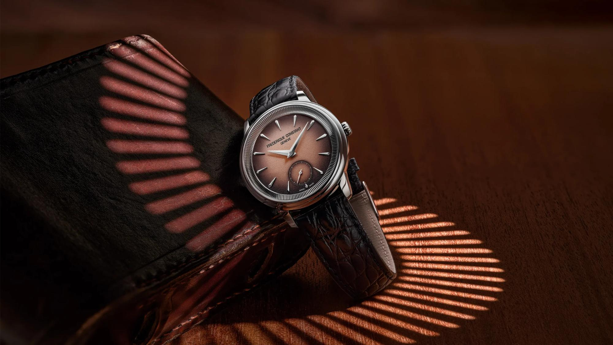 Een tijdloos icoon in een gelimiteerde oplage.
De Classics Moneta-collectie, die in recordtijd een absolute must-have is geworden, maakt de overstap naar een mechanisch uurwerk met deze exclusieve editie, gelimiteerd tot 999 exemplaren wereldwijd. Elk exemplaar is voorzien van de gravure "ONE OF 999" op de achterkant van de kast. Het horloge heeft een perfect uitgebalanceerde diameter van 38,50 mm, ideaal voor liefhebbers van klassieke uurwerken ge&iuml;nspireerd op de jaren 50. Het geheim schuilt in de flens, versierd met delicate ribbels die doen denken aan de randen van een munt. Dit unieke profiel omlijst een gerookt zalmkleurige wijzerplaat met een korrelige gradi&euml;nt, waarvan de zwarte buitenrand de Dauphine-wijzers en de spiegelgepolijste uurmarkeringen prachtig accentueert. Het horloge combineert perfect met een vintage alligatorband met een fijn schubbenpatroon. Om dit uurwerk aan te drijven, heeft Frederique Constant gekozen voor een hoogwaardig, handmatig opwindbaar uurwerk van de Zwitserse fabrikant La Joux-Perret. Dit uurwerk biedt een royale gangreserve van 63 uur, wat het uitzonderlijke karakter van deze gelimiteerde editie nog verder benadrukt.