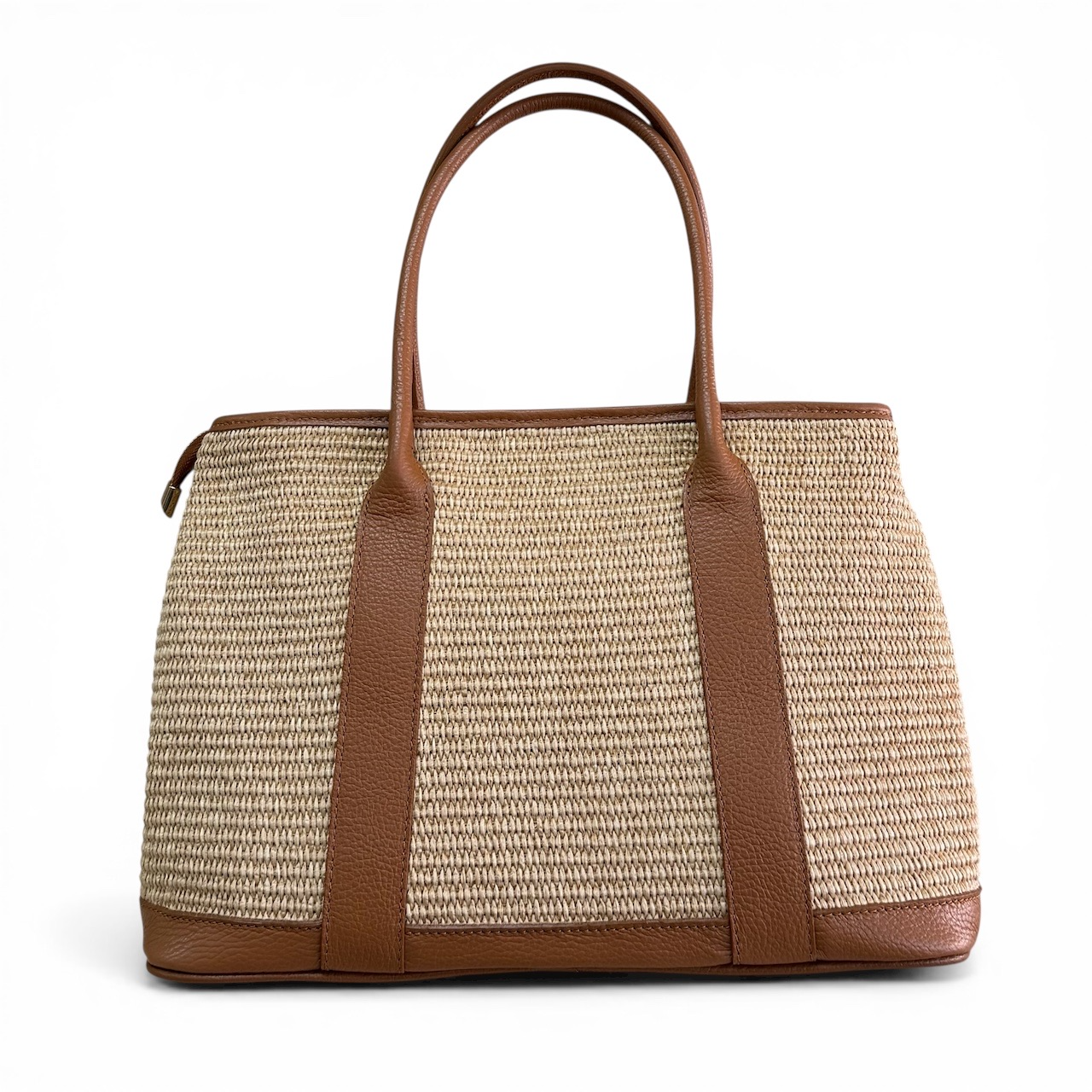 Handgemaakte raffia tas met leer &ndash; Made in Italy
Deze prachtige handgemaakte raffia tas met leren details is een stijlvolle en veelzijdige tas, rechtstreeks uit Itali&euml;. De combinatie van natuurlijk raffia en hoogwaardig leer geeft de tas een warme, tijdloze uitstraling. Een ideale tas voor wie houdt van Italiaans vakmanschap, natuurlijke materialen en een praktische indeling.
De tas is ruim genoeg voor al je dagelijkse essentials en is voorzien van een lange, afneembare leren schouderriem, zodat je de tas zowel in de hand als comfortabel over de schouder kunt dragen.

Praktische indeling
Deze ruime raffia tas is ontworpen met oog voor gebruiksgemak en beschikt over:
2 ruime hoofdvakken
1 hoofdvak met ritssluiting
Een tussenvak met rits voor het veilig opbergen van waardevolle spullen
2 handige steekvakken aan de binnenzijde
Een lange, afneembare schouderriem
Afmetingen: 25 cm hoog x 36 cm breed x 18 cm diep
Dankzij de verschillende vakken houd je je spullen overzichtelijk georganiseerd, terwijl de ruime vorm voldoende plaats biedt voor alles wat je dagelijks nodig hebt.
Handgemaakt in Itali&euml;
Elke tas wordt met zorg handgemaakt in Itali&euml;, waar traditioneel vakmanschap en aandacht voor detail centraal staan. Het natuurlijke raffia wordt gecombineerd met leer voor een stijlvolle uitstraling die zowel bij een casual als een elegante outfit past.
Deze Italiaanse raffia tas met leer is een perfecte keuze voor de zomer, vakantie, een dagje shoppen of als stijlvolle dagelijkse tas. Een uniek accessoire voor liefhebbers van handgemaakte Italiaanse tassen.

Productdetails

Materiaal: raffia en leer
Handgemaakt in Itali&euml;
2 hoofdvakken
1 hoofdvak met ritssluiting
Tussenvak met rits
2 steekvakken
Lange afneembare schouderriem
Afmetingen: 25 x 36 x 18 cm
Geschikt als handtas en schoudertas