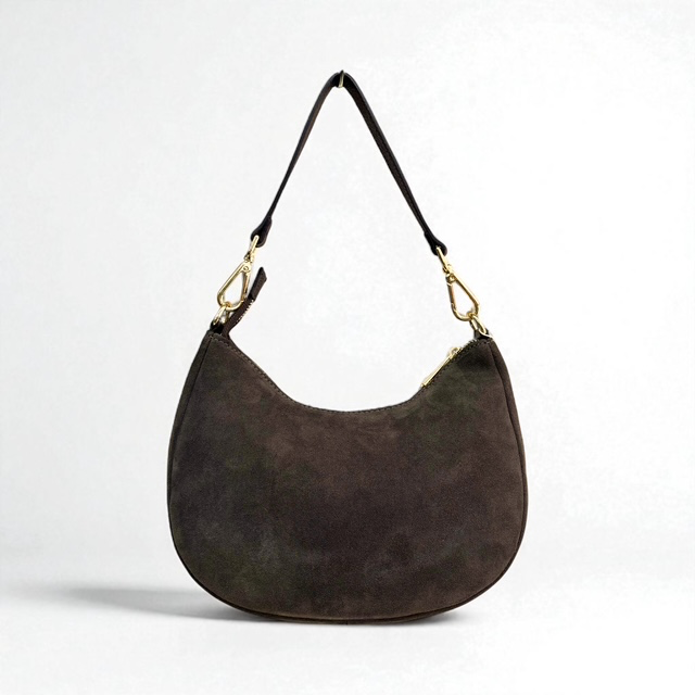 Su&egrave;de schoudertas met korte en lange schouderriem
Deze stijlvolle su&egrave;de schoudertas combineert een zachte, luxe uitstraling met praktisch draagcomfort. De tas is voorzien van een gladde korte schouderriem, waarmee je haar elegant en comfortabel over de schouder draagt.
Daarnaast wordt de tas geleverd met een lange, afneembare en verstelbare schouderriem. Hierdoor kun je de tas eenvoudig aanpassen aan jouw persoonlijke stijl en zowel over de schouder als crossbody dragen.

De tas sluit aan de bovenzijde met een ritssluiting. Het hoofdvak biedt voldoende ruimte voor je dagelijkse essentials. Binnenin vind je een extra ritsvak en twee steekvakken, zodat je kleinere spullen overzichtelijk kunt opbergen.

Productdetails:

Su&egrave;de schoudertas voor dames
Gladde korte schouderriem
Lange, afneembare en verstelbare schouderriem
Te dragen over de schouder of crossbody
Toprits
E&eacute;n ruim hoofdvak
Binnenvak met ritssluiting
Twee steekvakken
Geen voorvak
Afmetingen: 16 cm hoog x 26 cm breed x 9 cm diep
Een elegante en veelzijdige su&egrave;de tas voor dames, perfect voor dagelijks gebruik. De combinatie van het zachte su&egrave;de en de verschillende draagmogelijkheden maakt deze tas een stijlvolle aanvulling op iedere garderobe.