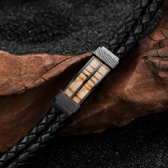 De wildernis sluimert in jou.

Wie luidruchtig moet zijn om op te vallen, heeft meestal niets te zeggen. Deze armband is precies het tegenovergestelde: hij ontleent zijn aanwezigheid aan de ingetogen kracht van echt leer en de ongetemde textuur van natuurlijk zebrano-hout.

Dit cre&euml;ert een stukje pure wildernis voor je pols. Een uiterst robuuste maar toch soepele partner die met elk avontuur een eigen karakter krijgt.

Jouw pols. Jouw territorium. Haal jouw unieke sieraad in huis!