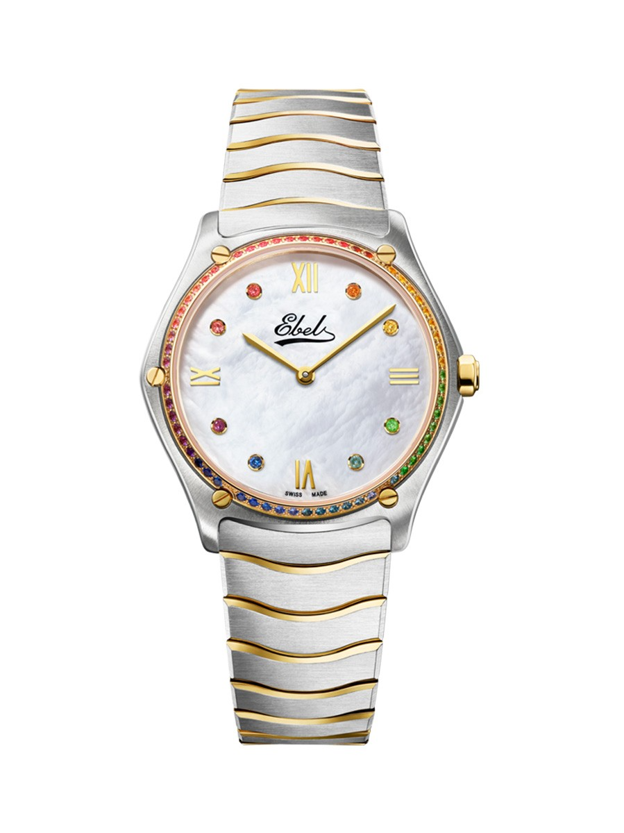 EBEL SPORT CLASSIC LIMITED EDITION 115TH ANNIVERSARY 33MM - 1216754 

Dit dameshorloge is onderdeel van de Ebel Sport Classic serie. Het horloge is een ode aan het sportief-klassieke horloge dat in de jaren zeventig en tachtig heel wat harten wist te veroveren. Het model is uitgegeven ter ere van het 115-jarige jubileum van Ebel, en is alleen dit jaar beperkt beschikbaar. 

Alle modellen in deze serie hebben een ronde horlogekast met daarin vijf opvallende 'schroeven'. De horloges zijn bovendien allemaal uitgerust met een antireflecterend saffierglas, een prachtige flexibele horlogeband met zogenaamde golven en een hoge kwaliteit vouwsluiting.

De 1216754 heeft een parelmoer wijzerplaat met goudkleurige wijzers en romeinse index. Op de wijzerplaat en in de bezel zijn prachtige briljant geslepen edelstenen geplaatst. De horlogeband is gemaakt van edelstaal gecombineerd met 18 karaat geelgoud. Ook in de horlogekast, schroeven en kroon zit 18 karaat geelgoud verwerkt. De kast heeft een diameter van 33 millimeter en is voorzien van een quartz uurwerk. Het model is bovendien tot 50 meter waterdicht, wat betekent dat hij om gehouden kan worden tijdens het zwemmen of douchen. Een iconisch en tijdloos horloge voor elegante dames met een uitstekende smaak. 