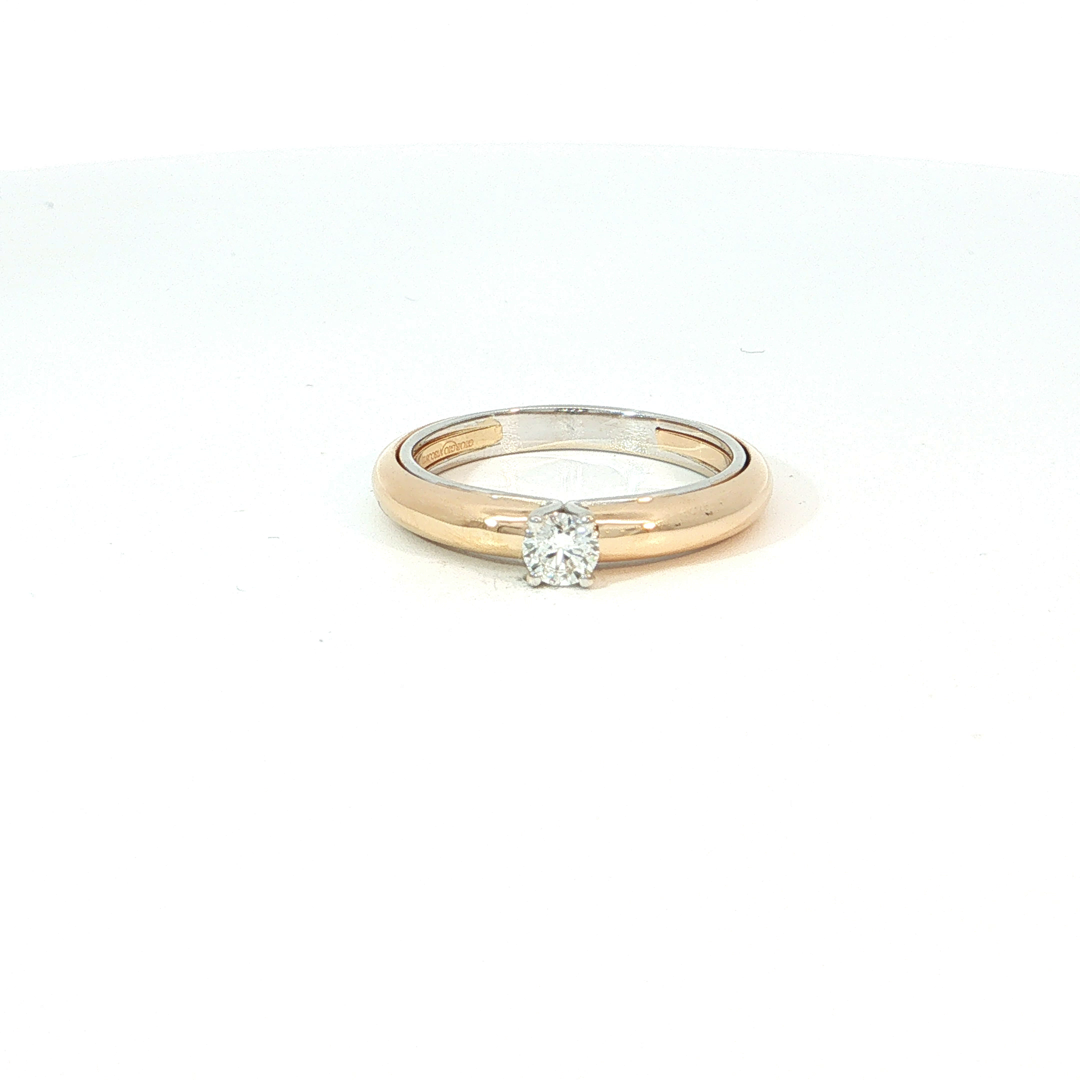 Een klassieke diamant met briljant slijpvorm vormt het middelpunt van deze elegante solitairring. De steen is stevig gezet in een gepolijste ros&eacute;gouden ringrail, wat zorgt voor een warm en romantisch contrast met de schittering van de diamant. Het ontwerp kenmerkt zich door een subtiel tweekleurig effect, waarbij een witgouden binnenring een modern accent toevoegt aan het traditionele silhouet.