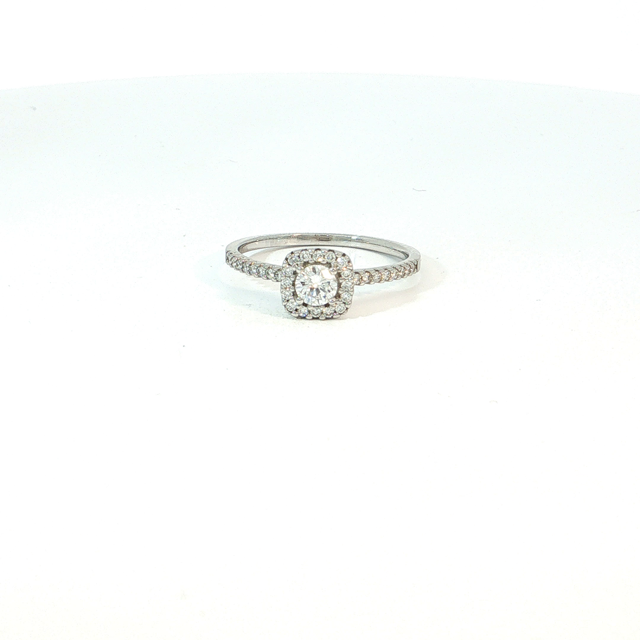 Een uitgesproken elegante ring met een verfijnde, luxueuze uitstraling. De centrale briljant wordt omringd door een sierlijke halo van kleinere diamanten, waardoor de steen optisch groter oogt en nog intenser schittert.
Ook de fijne ringband in 18 kt witgoud is bezet met briljanten, wat zorgt voor extra licht en een prachtig fonkelend geheel. De combinatie van de centrale diamant, de halo en de met diamant bezette schouders geeft deze ring een bijzonder rijke maar toch elegante uitstraling.
Een schitterende keuze als verlovingsring voor wie houdt van romantiek, verfijning en een juweel met echte pr&eacute;sence.