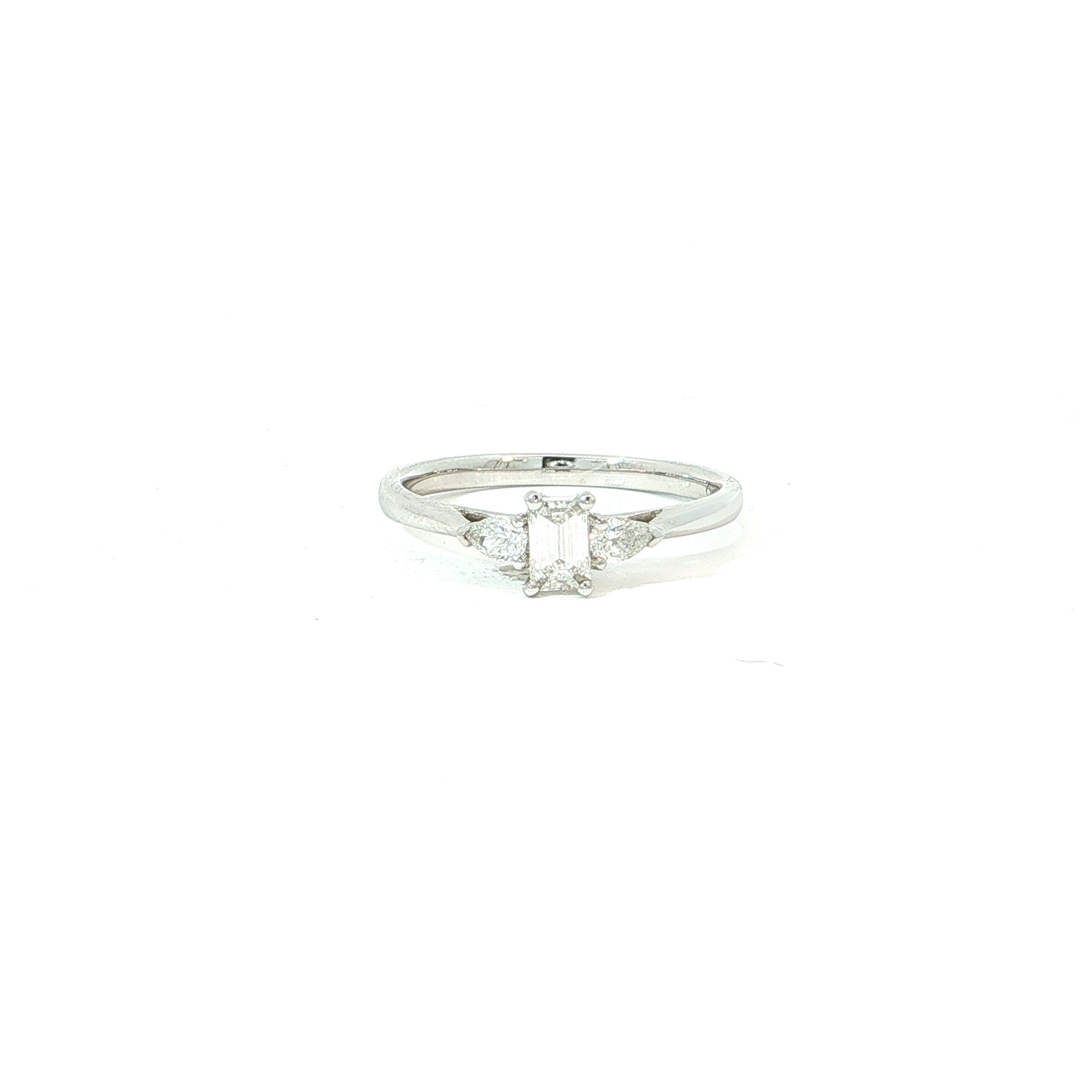 Een verfijnde trilogie ring in 18 kt witgoud met een elegante, moderne uitstraling. Centraal schittert een rechthoekig emerald-cut geslepen diamant, geflankeerd door twee verfijnde peervormige diamanten die het ontwerp extra licht en beweging geven.
De combinatie van de strakke lijnen van de emerald cut en de zachte vorm van de pear diamonds zorgt voor een bijzonder harmonieus geheel. De slanke witgouden ringband houdt het ontwerp luchtig en laat de diamanten volledig tot hun recht komen.
Een stijlvolle keuze als verlovingsring voor wie houdt van iets exclusievers dan de klassieke solitair, met een luxueuze uitstraling die tijdloos blijft.
