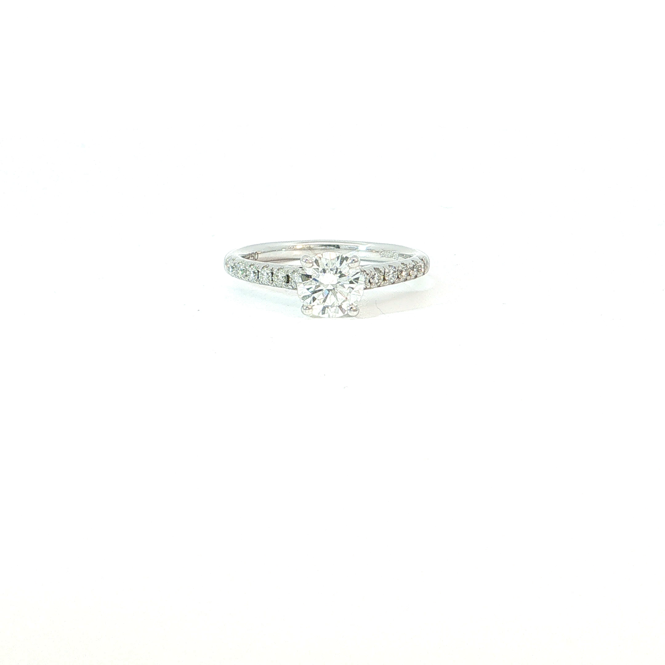 Deze 18 karaat witgouden ring zet de briljant volledig in de hoofdrol en versterkt haar schittering met een elegante rij kleinere diamanten langs de ringband. De centrale steen oogt daardoor nog groter en levendiger, terwijl het fijne pav&eacute; voor een luxueuze fonkeling zorgt bij elke beweging. De slanke vorm houdt het geheel verfijnd en vrouwelijk, met een perfecte balans tussen klassieke romantiek en moderne glamour. 

Een prachtige keuze als verlovingsring, maar ook als bijzonder juweel om een belangrijk moment te vieren. Voor wie niet wil kiezen tussen elegantie en schittering.