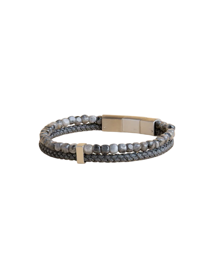 De armband in de kleur Leo Grey, beschikt over een dubbele band van canvasmateriaal en heeft een juweelmaat van 210. Deze elegante armband is een prachtige aanvulling voor elke gelegenheid en kan het beste om de pols worden gedragen, waarbij de dubbele banden stijlvol over elkaar liggen. Perfect voor dagelijks gebruik of speciale gelegenheden.