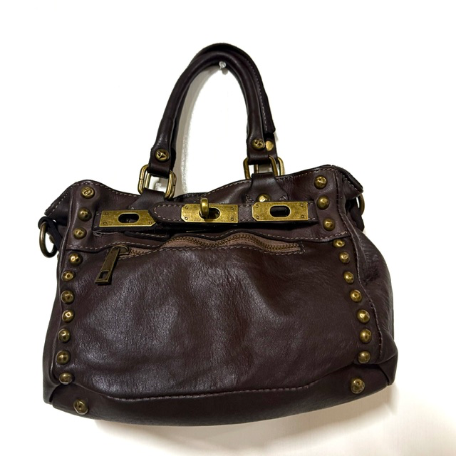 Stijlvolle handtas met elegante sluiting en studs
Op zoek naar een bijzondere handtas die elegantie en een stoere uitstraling perfect combineert? Deze fraaie handtas is een echte eyecatcher en geeft iedere outfit een stijlvolle finishing touch.

De tas is voorzien van een lange, afneembare en verstelbare schouderriem, zodat je haar zowel comfortabel over de schouder als crossbody kunt dragen. De elegante sluiting aan de voorzijde, ge&iuml;nspireerd op de klassieke Herm&egrave;s-stijl, geeft de handtas een luxe uitstraling. De praktische ritssluiting aan de voorzijde biedt extra gebruiksgemak.

Het hoofdvak sluit met een rits en is voorzien van een handig binnenvak met rits en een steekvak, ideaal om je dagelijkse essentials overzichtelijk op te bergen. De decoratieve studs aan de voorzijde en de beschermende studs aan de onderkant maken het stijlvolle ontwerp helemaal af.

Dankzij het compacte formaat is deze elegante handtas perfect voor een dagje uit, een etentje of een bijzondere gelegenheid. Een veelzijdige damestas die moeiteloos past bij zowel een casual als een chique outfit.

Productdetails

Stijlvolle handtas met luxe uitstraling
Lange, afneembare en verstelbare schouderriem
Fraaie sluiting in Herm&egrave;s-stijl
Extra ritsvak aan de voorzijde
E&eacute;n hoofdvak met ritssluiting
Binnenvak met rits en praktisch steekvak
Decoratieve studs aan de voorzijde
Beschermende studs aan de onderkant
Afmetingen: 15 cm hoog &times; 25 cm breed &times; 12 cm diep