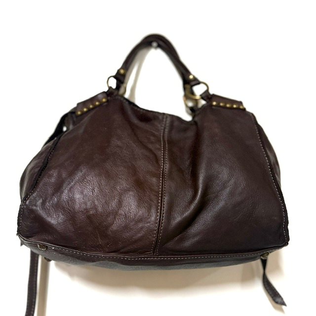 Leren handtas van gewassen leer met studs &ndash; stijlvol en praktisch
Ben je op zoek naar een stijlvolle leren handtas die elegantie en praktisch gemak combineert? Deze fraaie handtas van gewassen leer heeft een stoere, eigentijdse uitstraling en is dankzij de decoratieve studs aan de voor- en achterzijde een echte blikvanger.

De tas is niet alleen mooi, maar ook bijzonder praktisch ingedeeld. Het ruime interieur bestaat uit twee hoofdvakken, gescheiden door een handig ritsvak. Daarnaast beschikt de tas over een extra ritsvak aan de achterzijde en een steekvak aan de binnenkant, zodat je al je dagelijkse essentials overzichtelijk kunt opbergen.

De handtas is volledig gevoerd en voorzien van een afneembare, verstelbare schouderriem. Draag haar elegant in de hand of comfortabel over de schouder. De metalen voetjes aan de onderkant beschermen de tas en geven het ontwerp een mooie, verzorgde afwerking.

Een veelzijdige leren damestas die perfect past bij een casual outfit, maar ook prachtig combineert met een meer geklede look.

Productdetails

Materiaal: gewassen leer
Gevoerd interieur
Twee hoofdvakken met een tussenvak met ritssluiting
Extra ritsvak aan de achterzijde
Handig steekvak aan de binnenzijde
Decoratieve studs aan de voor- en achterzijde
Afneembare en verstelbare schouderriem
Metalen beschermvoetjes aan de onderkant
Afmetingen: 21 cm hoog &times; 33 cm breed &times; 10 cm diep