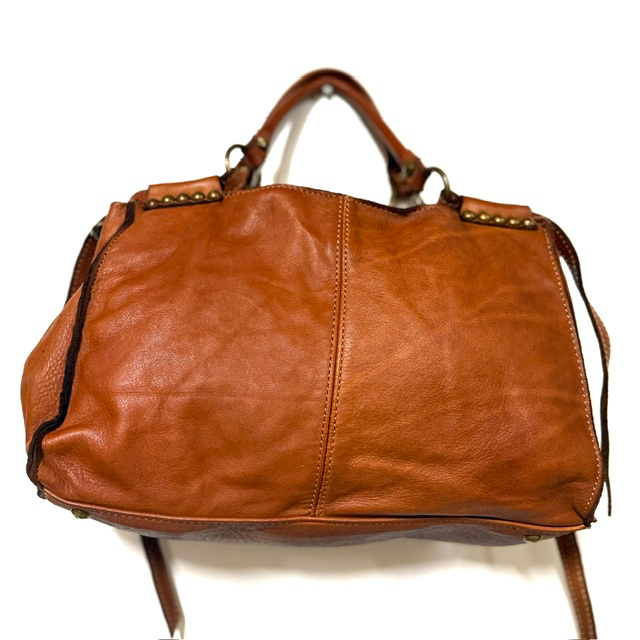 Leren handtas van gewassen leer met studs &ndash; stijlvol en praktisch
Ben je op zoek naar een stijlvolle leren handtas die elegantie en praktisch gemak combineert? Deze fraaie handtas van gewassen leer heeft een stoere, eigentijdse uitstraling en is dankzij de decoratieve studs aan de voor- en achterzijde een echte blikvanger.

De tas is niet alleen mooi, maar ook bijzonder praktisch ingedeeld. Het ruime interieur bestaat uit twee hoofdvakken, gescheiden door een handig ritsvak. Daarnaast beschikt de tas over een extra ritsvak aan de achterzijde en een steekvak aan de binnenkant, zodat je al je dagelijkse essentials overzichtelijk kunt opbergen.

De handtas is volledig gevoerd en voorzien van een afneembare, verstelbare schouderriem. Draag haar elegant in de hand of comfortabel over de schouder. De metalen voetjes aan de onderkant beschermen de tas en geven het ontwerp een mooie, verzorgde afwerking.

Een veelzijdige leren damestas die perfect past bij een casual outfit, maar ook prachtig combineert met een meer geklede look.

Productdetails

Materiaal: gewassen leer
Gevoerd interieur
Twee hoofdvakken met een tussenvak met ritssluiting
Extra ritsvak aan de achterzijde
Handig steekvak aan de binnenzijde
Decoratieve studs aan de voor- en achterzijde
Afneembare en verstelbare schouderriem
Metalen beschermvoetjes aan de onderkant
Afmetingen: 21 cm hoog &times; 33 cm breed &times; 10 cm diep