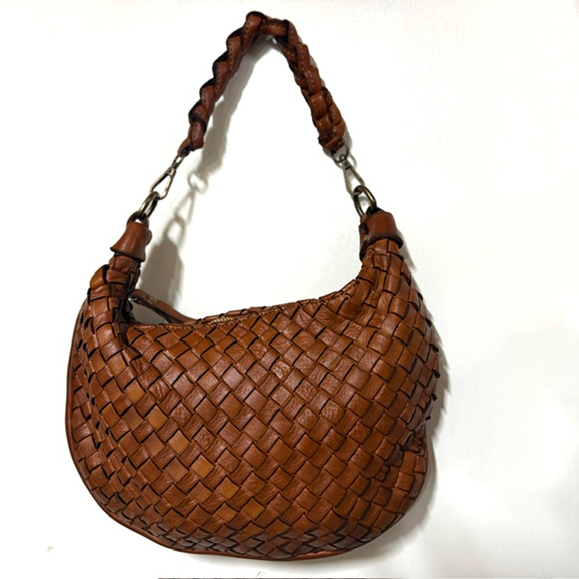 Gevlochten leren tas met geknoopte schouderriem
Op zoek naar een stijlvolle tas met een unieke uitstraling? Deze prachtige gevlochten leren tas is een echte eyecatcher! Het verfijnde vlechtwerk geeft de tas een luxe en speels karakter, terwijl de geknoopte korte schouderriem zorgt voor een trendy en eigentijdse look.

De tas is voorzien van een korte, geknoopte en afneembare schouderriem &eacute;n een lange, afneembare en verstelbare schouderriem. Zo kun je de tas op verschillende manieren dragen: elegant in de hand, comfortabel over de schouder of praktisch crossbody.

Het hoofdvak sluit met een rits en biedt voldoende ruimte voor je dagelijkse essentials. Onder de hoofdrits bevinden zich extra ritsvakken en een handig steekvak, zodat je je spullen overzichtelijk kunt opbergen.

Dankzij het compacte formaat en het bijzondere gevlochten design is deze leren damestas perfect voor dagelijks gebruik, een dagje uit of een avondje weg. Een veelzijdige tas die moeiteloos past bij zowel een casual als een elegante outfit.

Productdetails

Materiaal: leer
Fraai gevlochten design
Korte, geknoopte en afneembare schouderriem
Lange, afneembare en verstelbare schouderriem
Hoofdvak met ritssluiting
Extra ritsvakken onder de hoofdrits
Handig steekvak
Afmetingen: 20 cm hoog &times; 22 cm breed &times; 5 cm diep