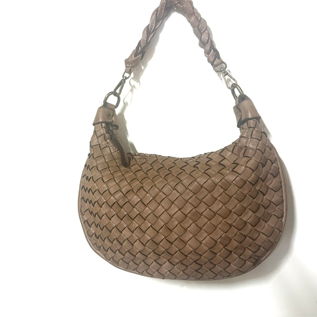 Gevlochten leren tas met geknoopte schouderriem
Op zoek naar een stijlvolle tas met een unieke uitstraling? Deze prachtige gevlochten leren tas is een echte eyecatcher! Het verfijnde vlechtwerk geeft de tas een luxe en speels karakter, terwijl de geknoopte korte schouderriem zorgt voor een trendy en eigentijdse look.

De tas is voorzien van een korte, geknoopte en afneembare schouderriem &eacute;n een lange, afneembare en verstelbare schouderriem. Zo kun je de tas op verschillende manieren dragen: elegant in de hand, comfortabel over de schouder of praktisch crossbody.

Het hoofdvak sluit met een rits en biedt voldoende ruimte voor je dagelijkse essentials. Onder de hoofdrits bevinden zich extra ritsvakken en een handig steekvak, zodat je je spullen overzichtelijk kunt opbergen.

Dankzij het compacte formaat en het bijzondere gevlochten design is deze leren damestas perfect voor dagelijks gebruik, een dagje uit of een avondje weg. Een veelzijdige tas die moeiteloos past bij zowel een casual als een elegante outfit.

Productdetails

Materiaal: leer
Fraai gevlochten design
Korte, geknoopte en afneembare schouderriem
Lange, afneembare en verstelbare schouderriem
Hoofdvak met ritssluiting
Extra ritsvakken onder de hoofdrits
Handig steekvak
Afmetingen: 20 cm hoog &times; 22 cm breed &times; 5 cm diep