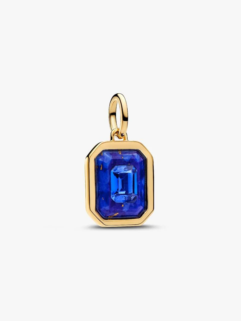 Geometrie wordt hemels. Een imitatie van lapis lazuli omlijst een smaragdgeslepen blauw kristal op deze vergulde hangende bedel, waardoor deze diepte en structuur krijgt.

