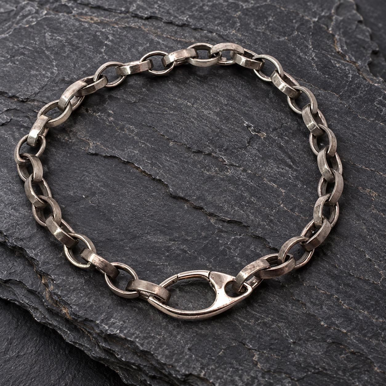 Markantes Herrenarmband aus Silber &ndash; Ausdrucksstark & zeitlos

Charakterstark. Puristisch. Unverwechselbar.

Dieses au&szlig;ergew&ouml;hnliche Silberarmband &uuml;berzeugt durch seine markante Kettengliederung und seinen individuellen, handwerklichen Charakter.

Die kr&auml;ftigen, l&auml;nglich-ovalen Kettenglieder mit ihren sanft abgerundeten Kanten verleihen dem Armband eine ausdrucksstarke Optik. Die lebendige, leicht unregelm&auml;&szlig;ige Oberfl&auml;che des Silbers unterstreicht den urspr&uuml;nglichen Charme des Schmuckst&uuml;cks.

Ein besonderer Blickfang ist der gro&szlig;z&uuml;gig gestaltete, tropfenf&ouml;rmige Karabinerverschluss, der sich harmonisch in das Design einf&uuml;gt und zugleich als dekoratives Element wirkt.

Ob zu Jeans und l&auml;ssigem Hemd oder als markantes Detail zu einem eleganten Outfit &ndash; dieses Armband setzt ein selbstbewusstes Statement, ohne aufdringlich zu wirken.

Details:

Material: Silber

Design: Kr&auml;ftige, l&auml;nglich-ovale Kettenglieder

Oberfl&auml;che: Lebendig strukturiert mit dezentem Silberglanz

Verschluss: Markanter, tropfenf&ouml;rmiger Karabiner

Stil: Maskulin, modern, zeitlos

Tragbar als Herrenarmband oder Unisex-Schmuckst&uuml;ck

Ein Schmuckst&uuml;ck mit Ecken und Kanten im Charakter &ndash; und sanft gerundeten Formen im Design.