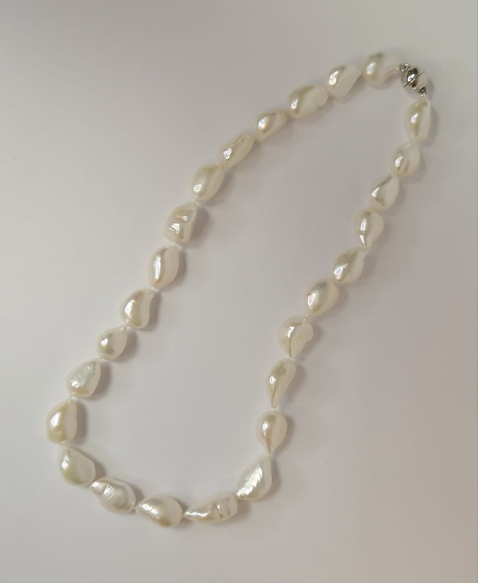 De Kobu Parel Collier Baroque, modelnummer Baroque parelcollier, is een verfijnde ketting. Dit parelcollier straalt elegantie uit met zijn barokke parels. Draag het als een statement stuk over een eenvoudige blouse of jurk voor een verfijnde look. Perfect voor speciale gelegenheden of om alledaagse outfits op te fleuren.