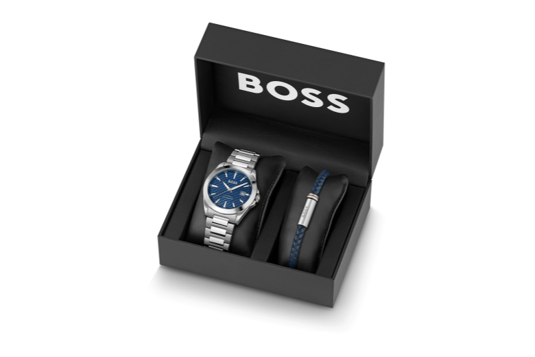 De Hugo Boss Heren Horloge Giftset (model 1570206) bevat een stijlvol horloge met een zilverkleurige, roestvrijstalen kast en band. Het heeft een blauwe wijzerplaat met strepenindex, mineraalglas, datumfunctie, analoge kwartsbeweging en waterbestendigheid tot 5 ATM. Draag het horloge als een elegant polssieraad voor zowel formele als informele gelegenheden. Inclusief armband.